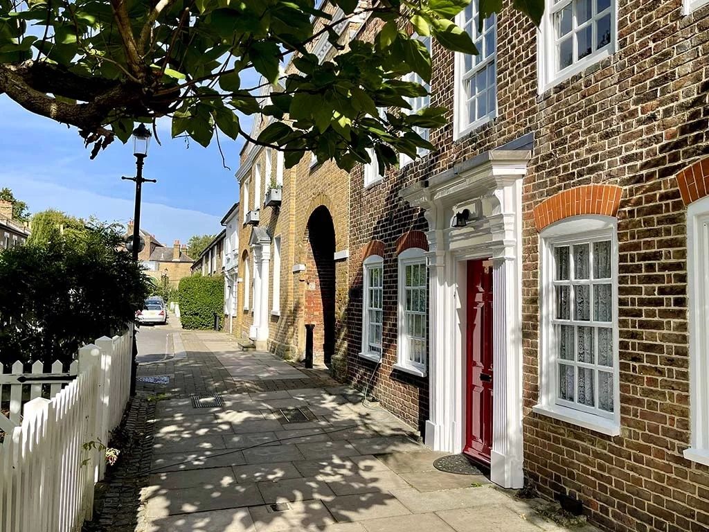 Weatherboarded cottages along a lane in Enfield