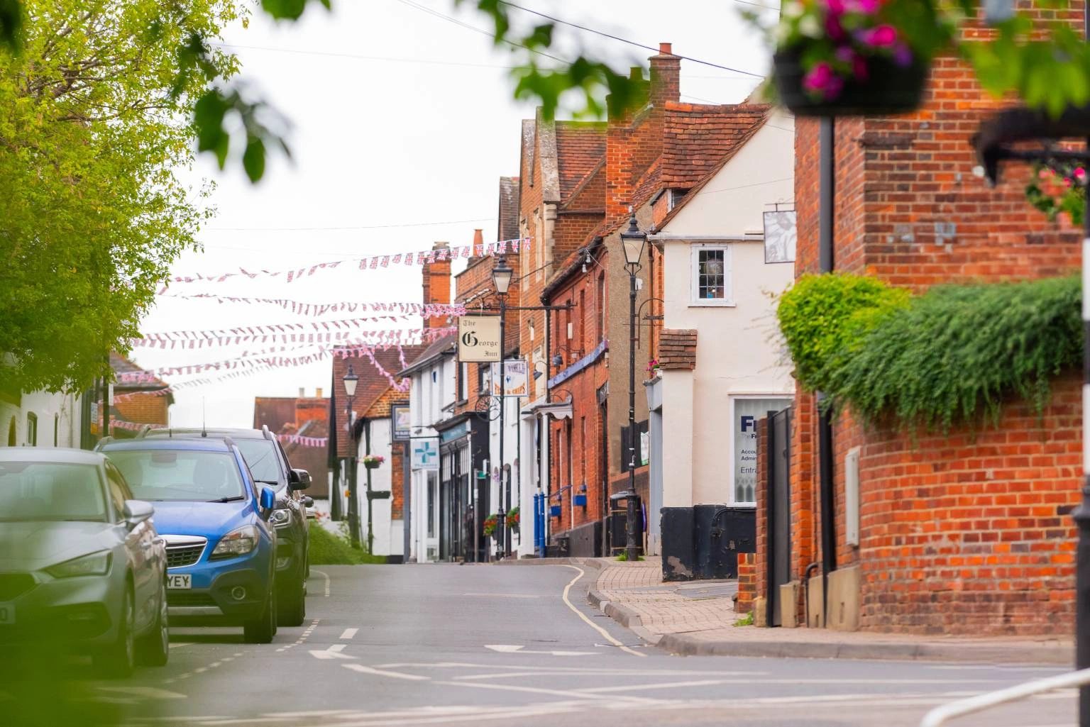 Street of brick buildings with hanging flower baskets in Slough