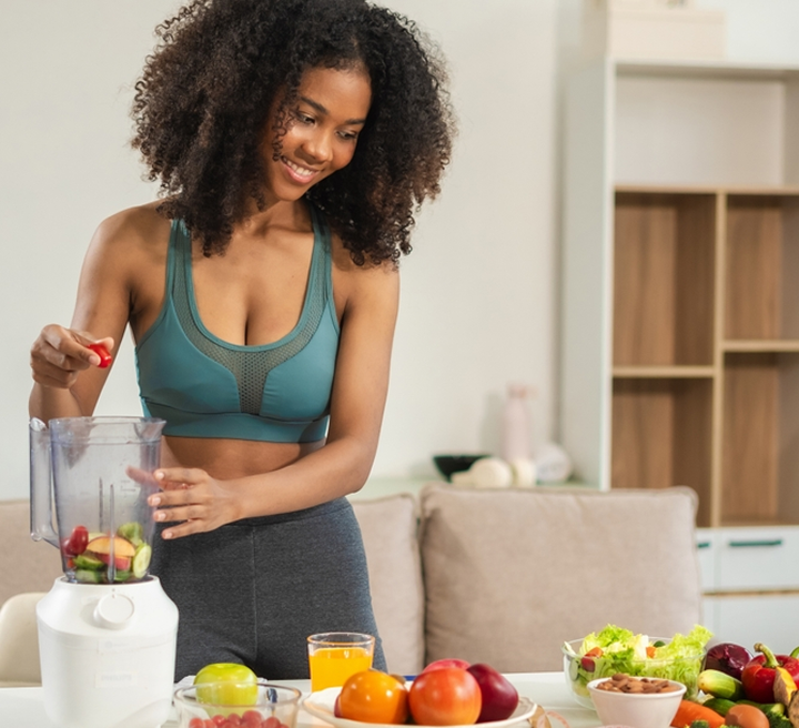 Woman preparing a healthy smoothie in her kitchen