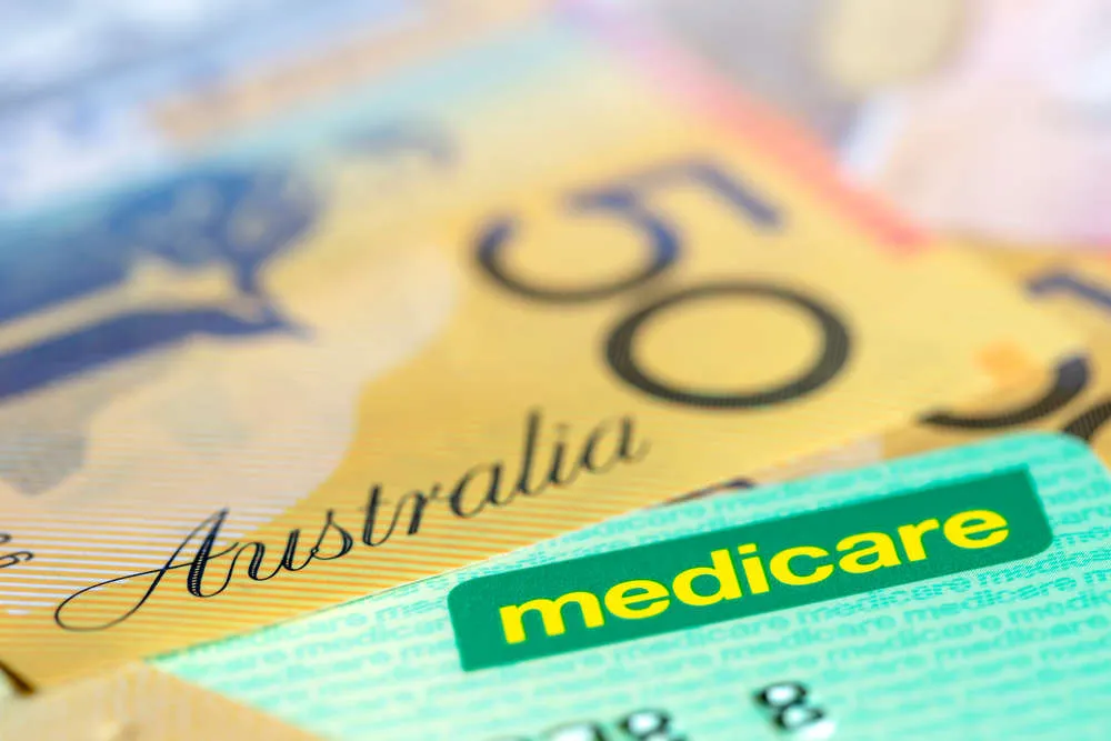 Medicare card resting on an Australian fifty-dollar note