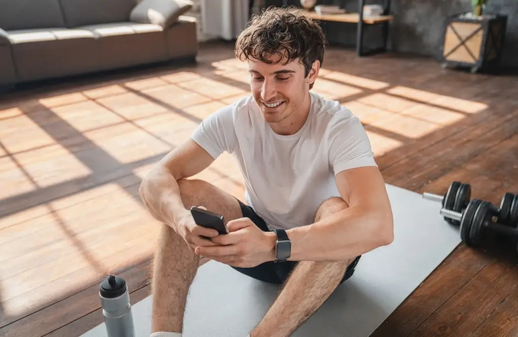 Man checking his phone after exercise as part of ongoing dietitian support