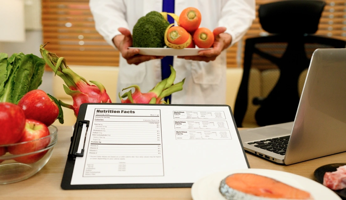 Nutrition assessment form beside fresh produce and a laptop