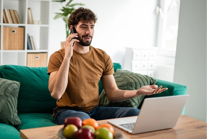 Man speaking with an online dietitian while using a laptop at home