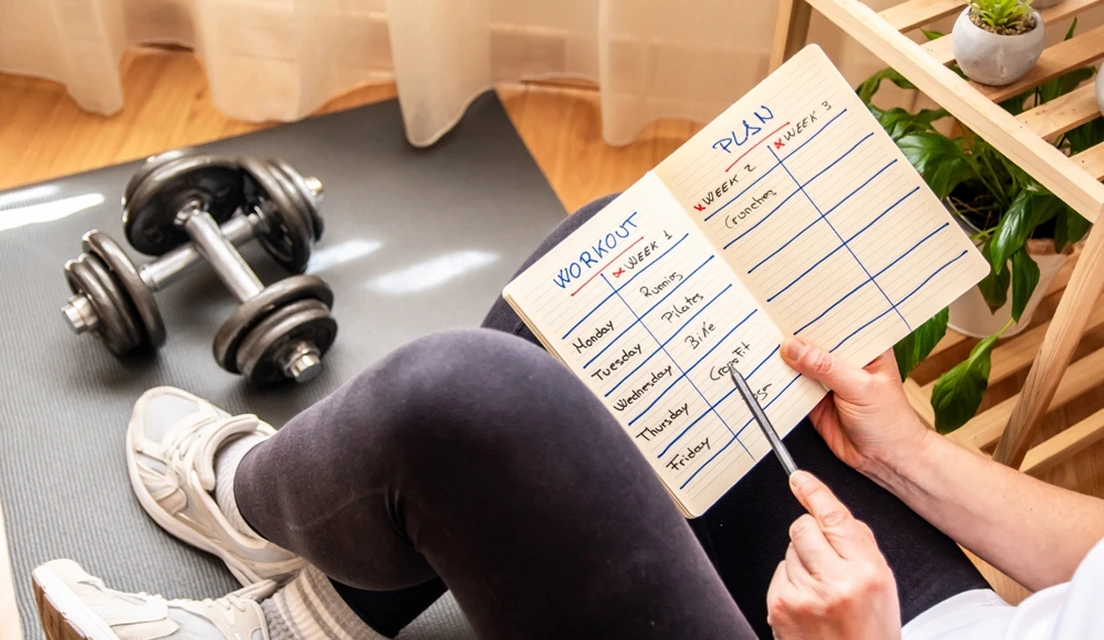 Personalised nutrition and fitness plan beside exercise gear and healthy food