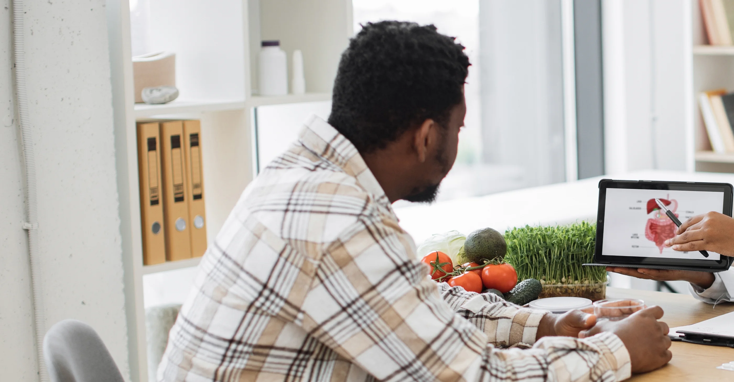 Man speaking with an online clinical dietitian while preparing vegetables