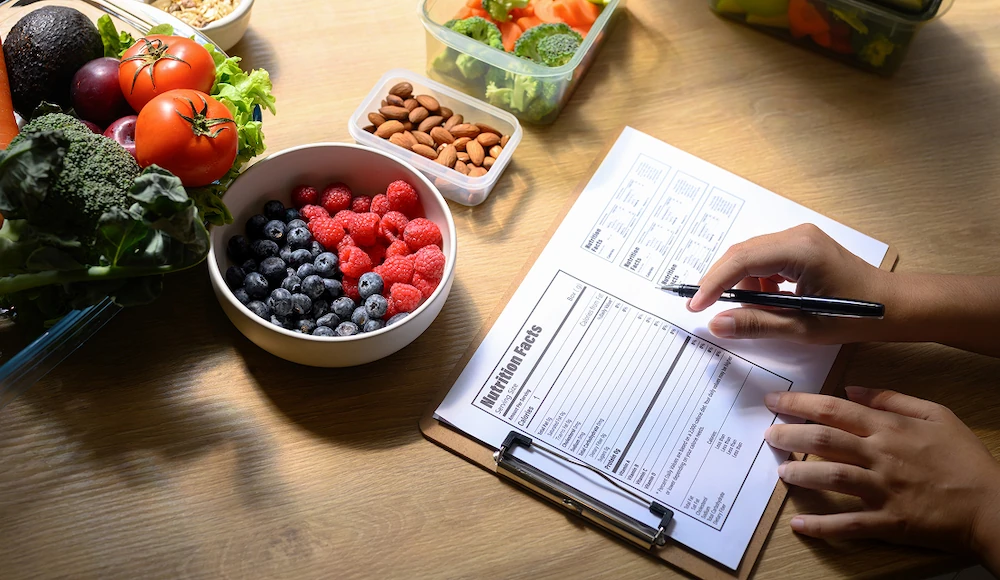 Nutrition assessment form beside berries, nuts and fresh vegetables