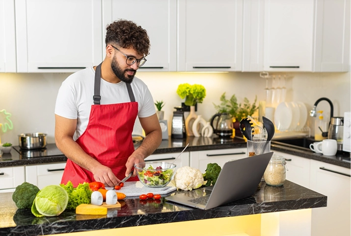 Man preparing vegetables while following online dietitian guidance