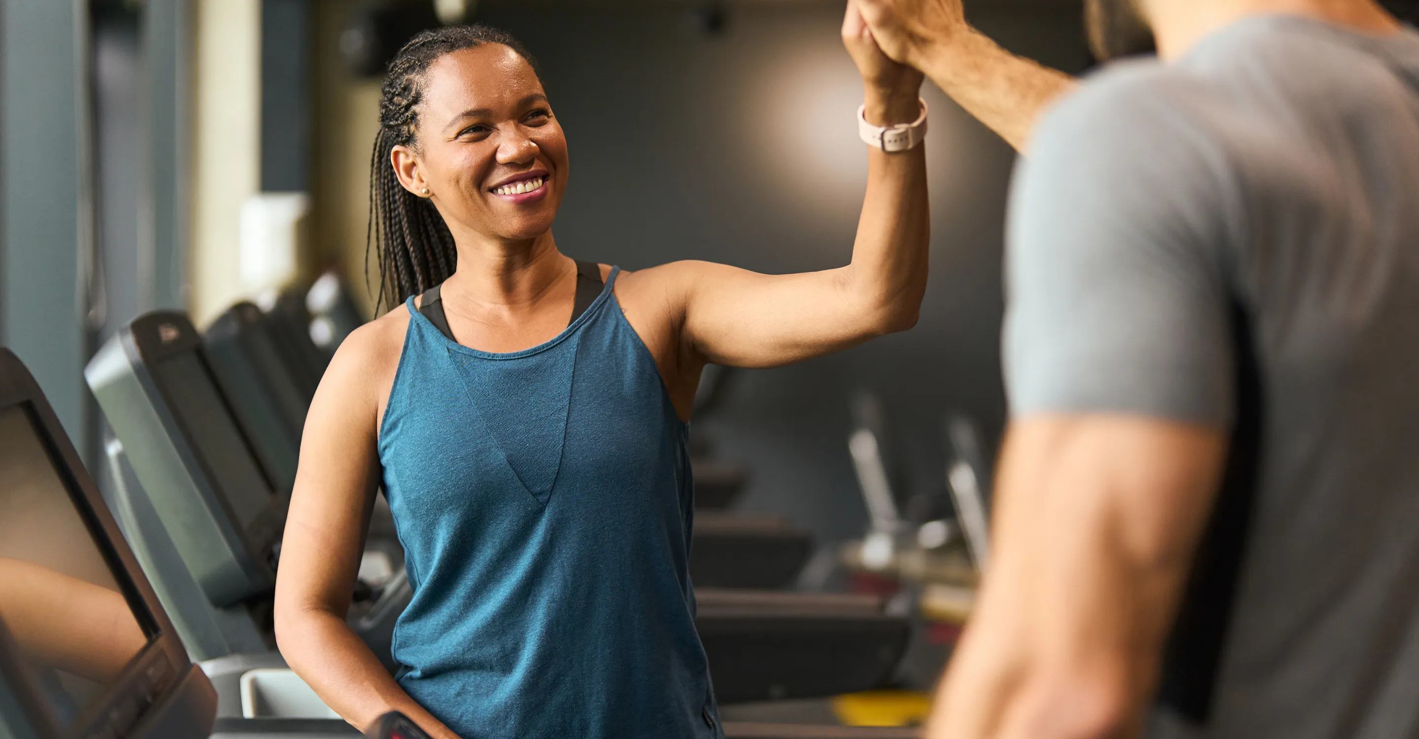 Woman high-fiving her trainer after completing a gym session