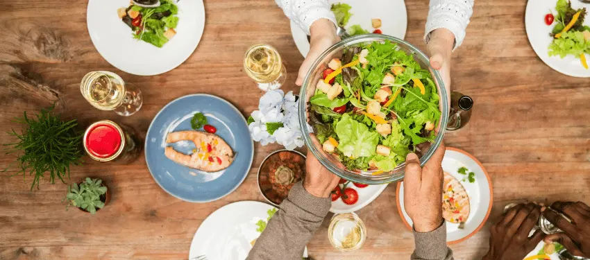 People sharing a balanced meal with salads, vegetables and fish