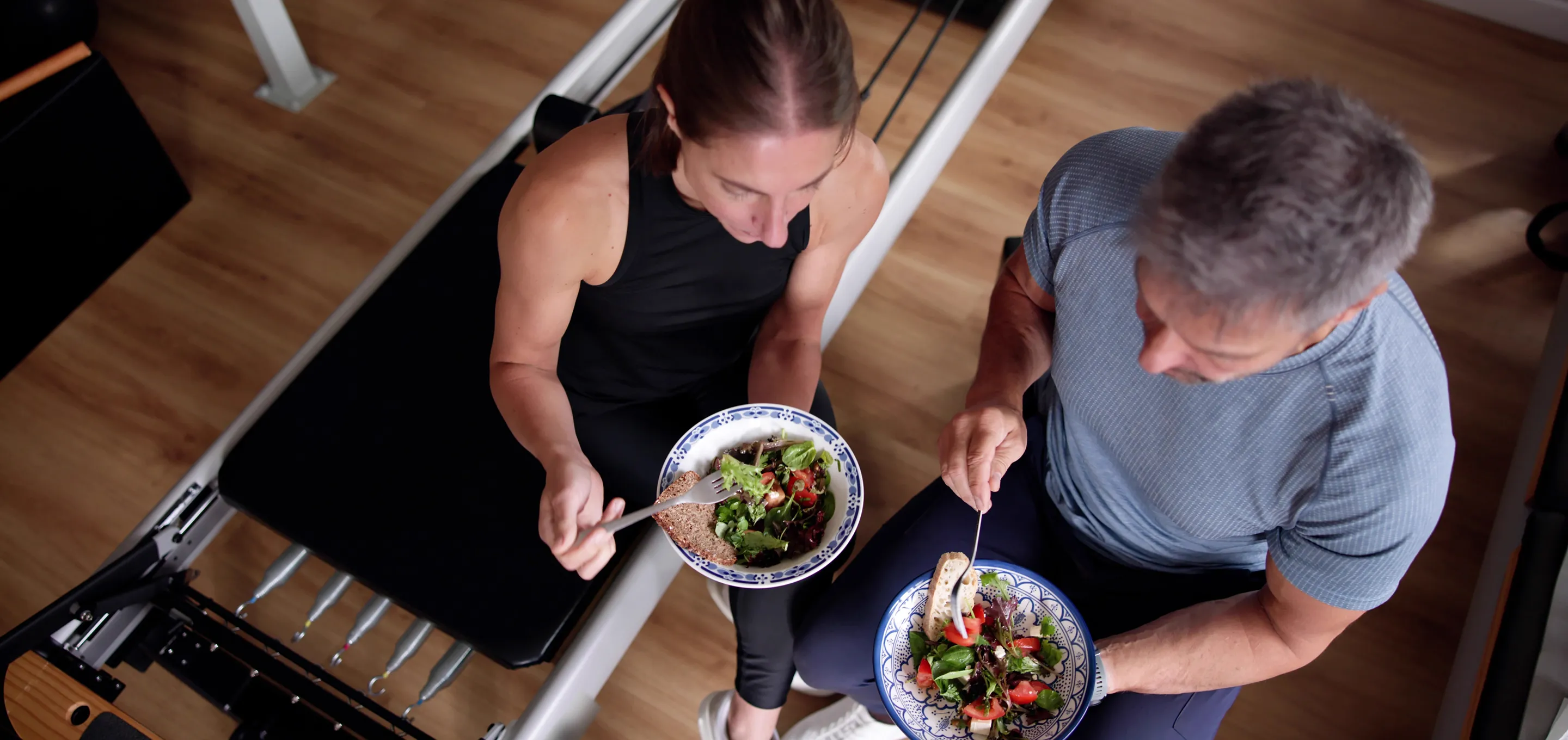 Two people sharing colourful salads as part of balanced eating