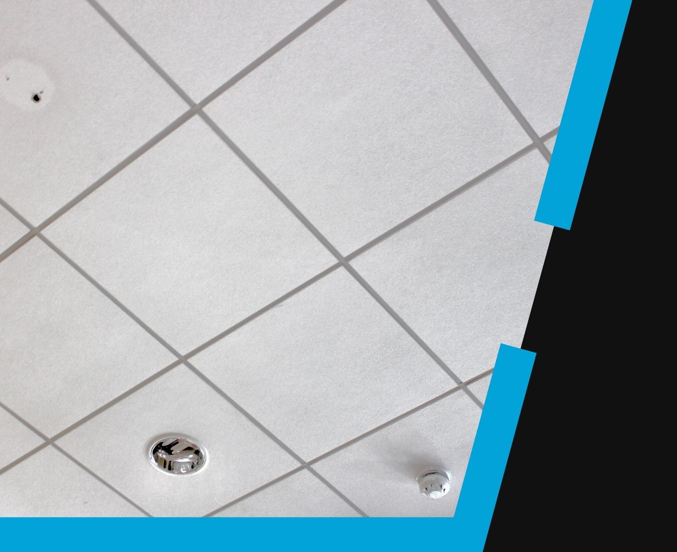 Ceiling with white square tiles arranged in a grid, featuring a recessed light fixture and a smoke detector, bordered by a black and blue angular frame on the right and bottom edges.