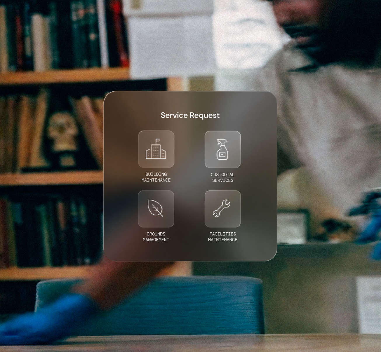 Overlay menu titled 'Service Request' with four icons and labels: building maintenance with a building icon, custodial services with a spray bottle icon, grounds management with a leaf icon, and facilities maintenance with a wrench icon, over a blurred background of a person working in a room with bookshelves.