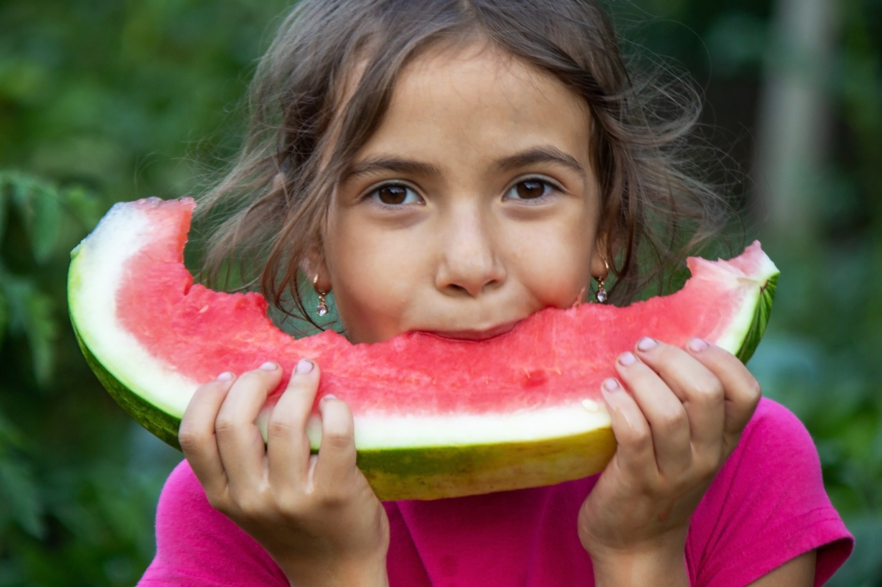A child holding a fresh watermelon