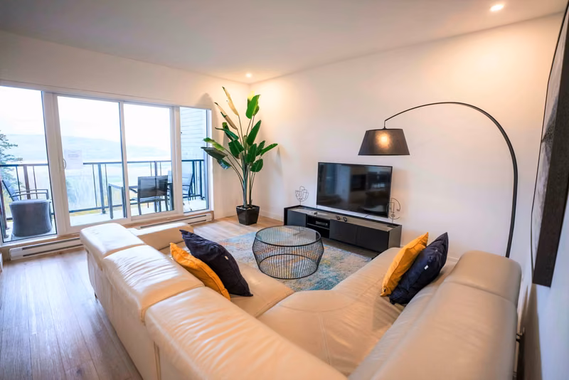 Salon du condo 205 avec vue sur le fleuve Saint-Laurent, Aurea Charlevoix