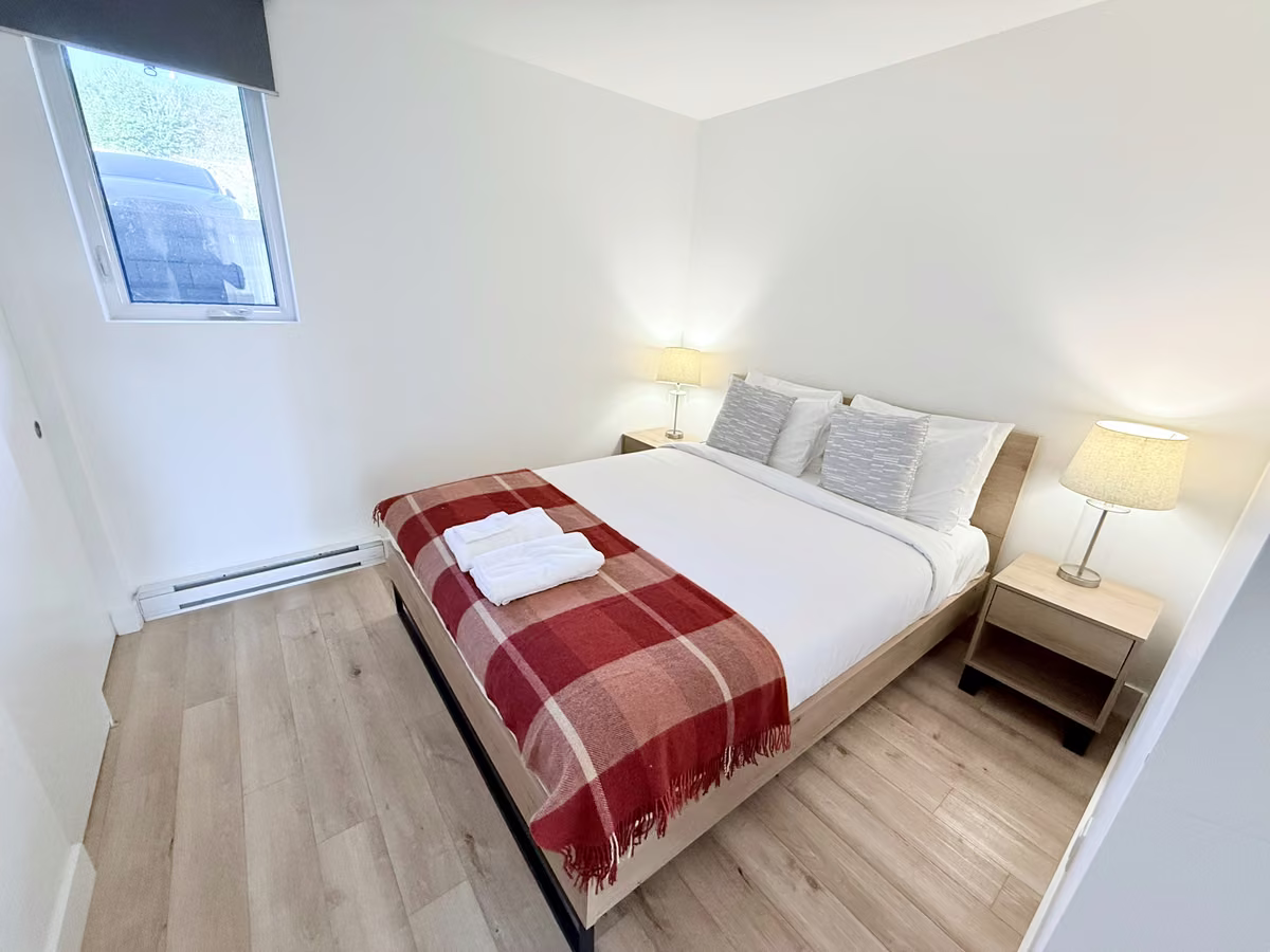 Chambre du condo 101 avec literie blanche, Aurea Charlevoix