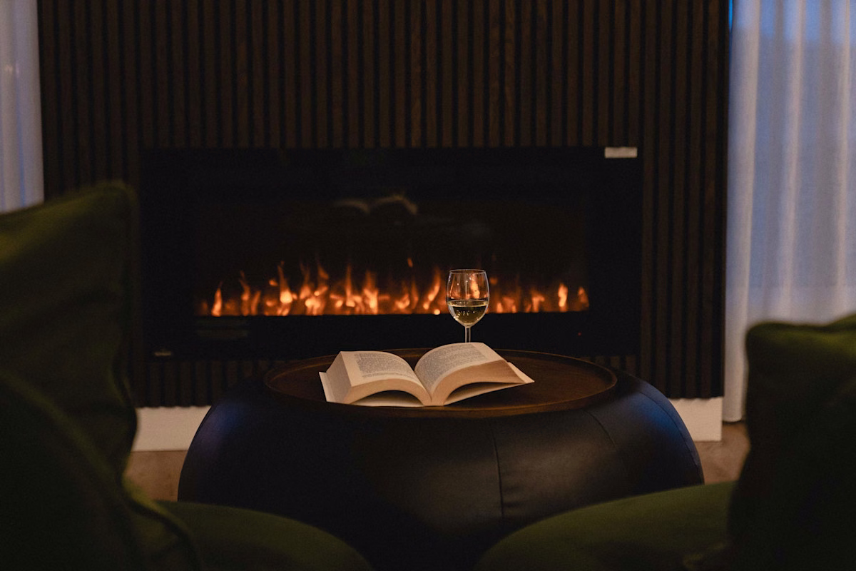 Foyer électrique du condo 404 avec livre ouvert, Aurea Charlevoix