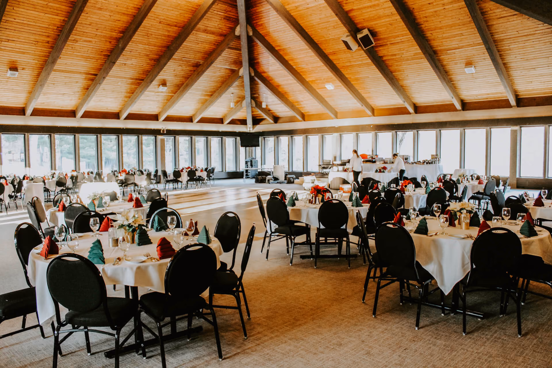 Spacious event and catering venue at Kenyon Inn & Restaurant with round dining tables beneath a vaulted wood-beam ceiling.