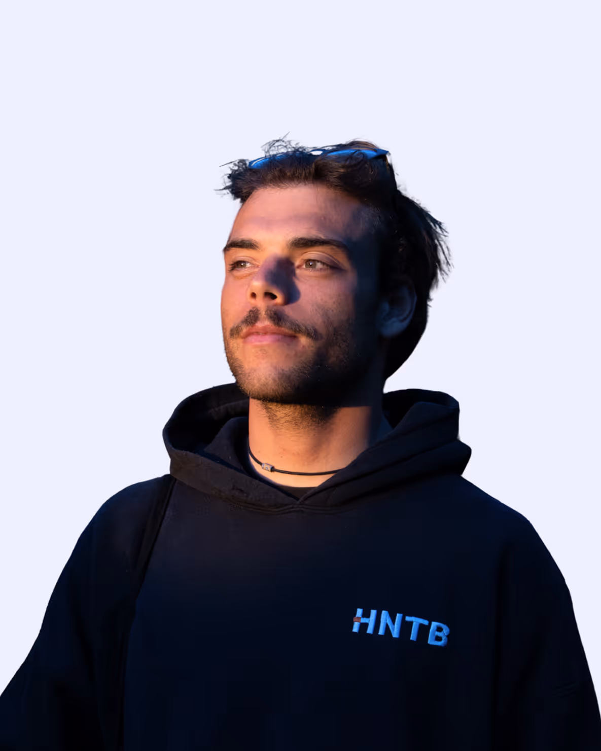 Man with mustache wearing black HNTB hoodie and blue sunglasses on head looking to the side.