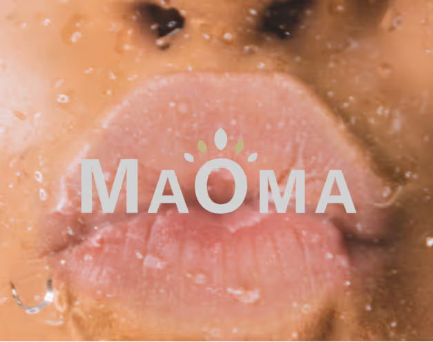 Close-up of a person's lips pressed against a wet glass surface with the word 'MAOMA' overlaid on the image.
