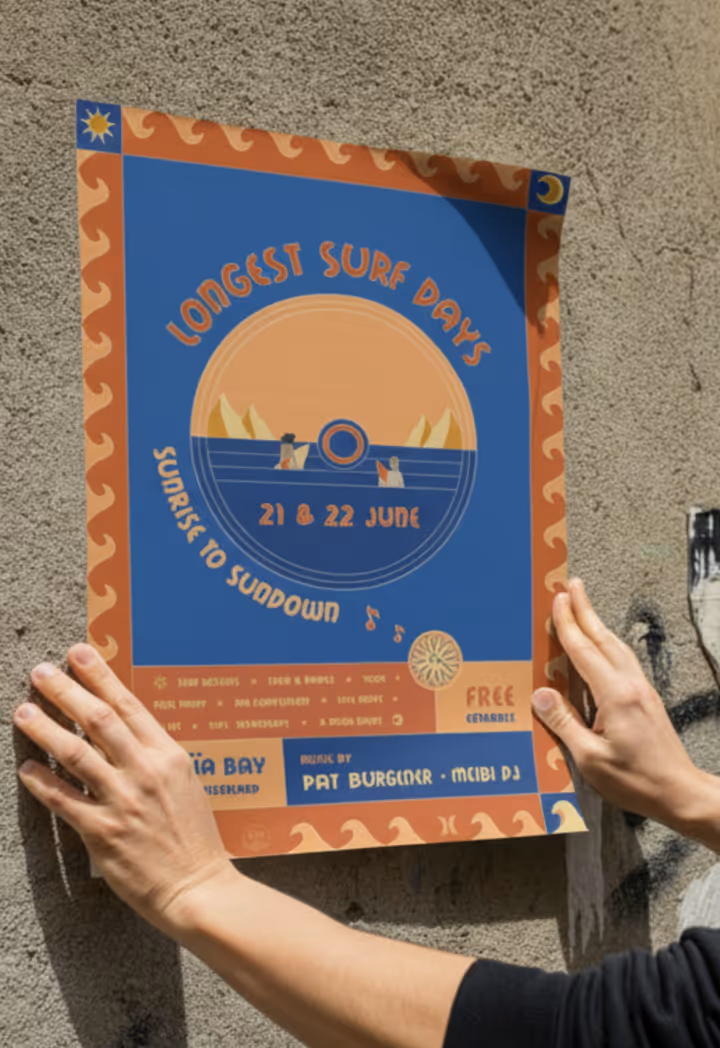 Person posting a colorful poster on a textured wall announcing 'Longest Surf Days' event on 21 & 22 June with a sunrise to sundown theme.