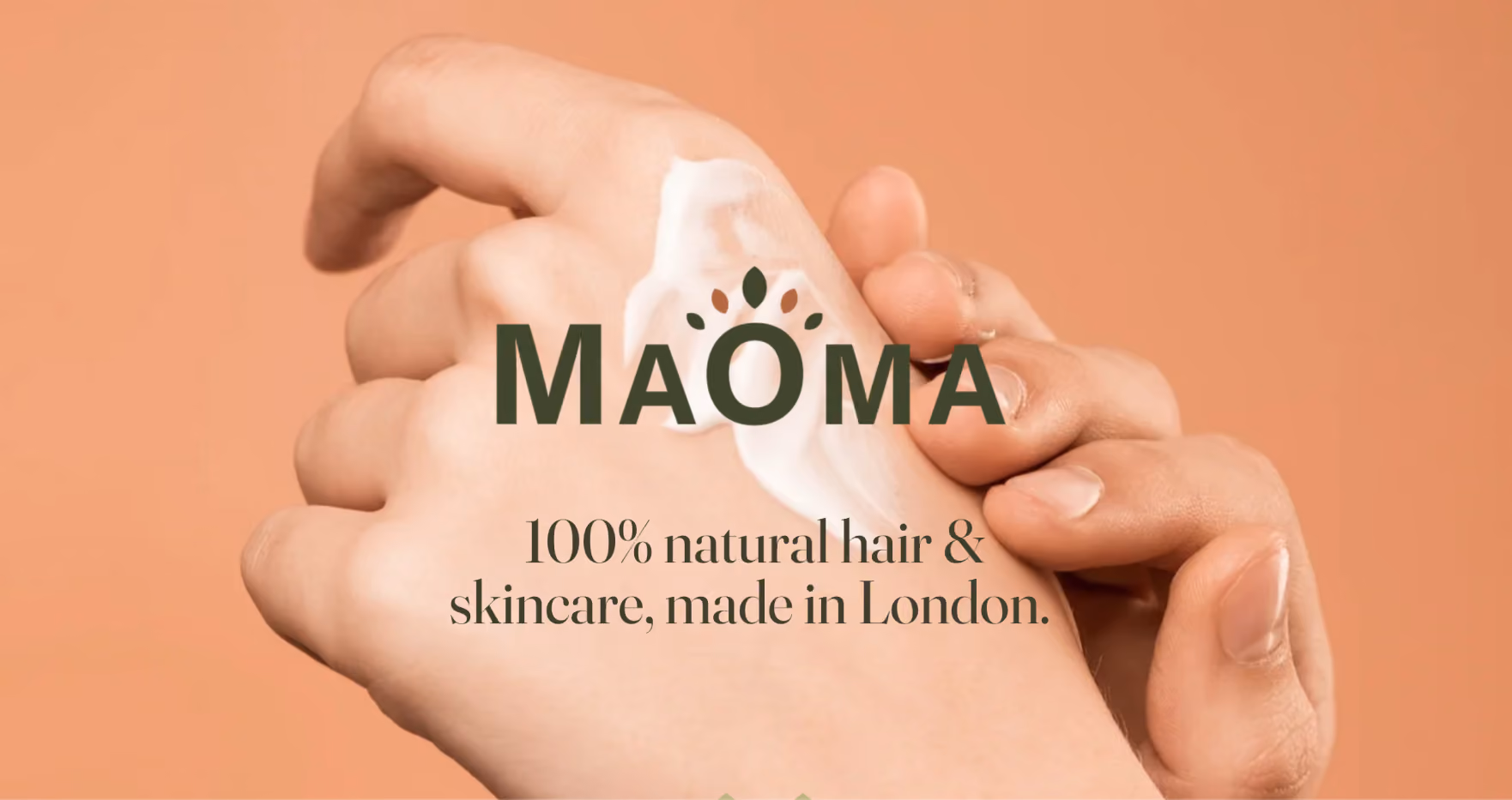 Close-up of a hand applying cream on the back of another hand with Maoma brand text and '100% natural hair & skincare, made in London.'