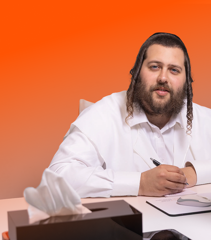 Man with beard and side curls in white shirt writing with pen at desk with tissue box and mouse.