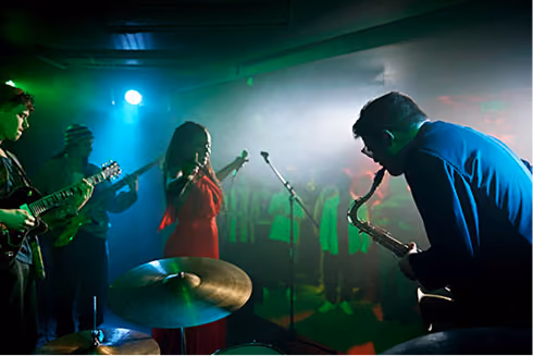 A band with a singer, saxophone player, and drummer on stage