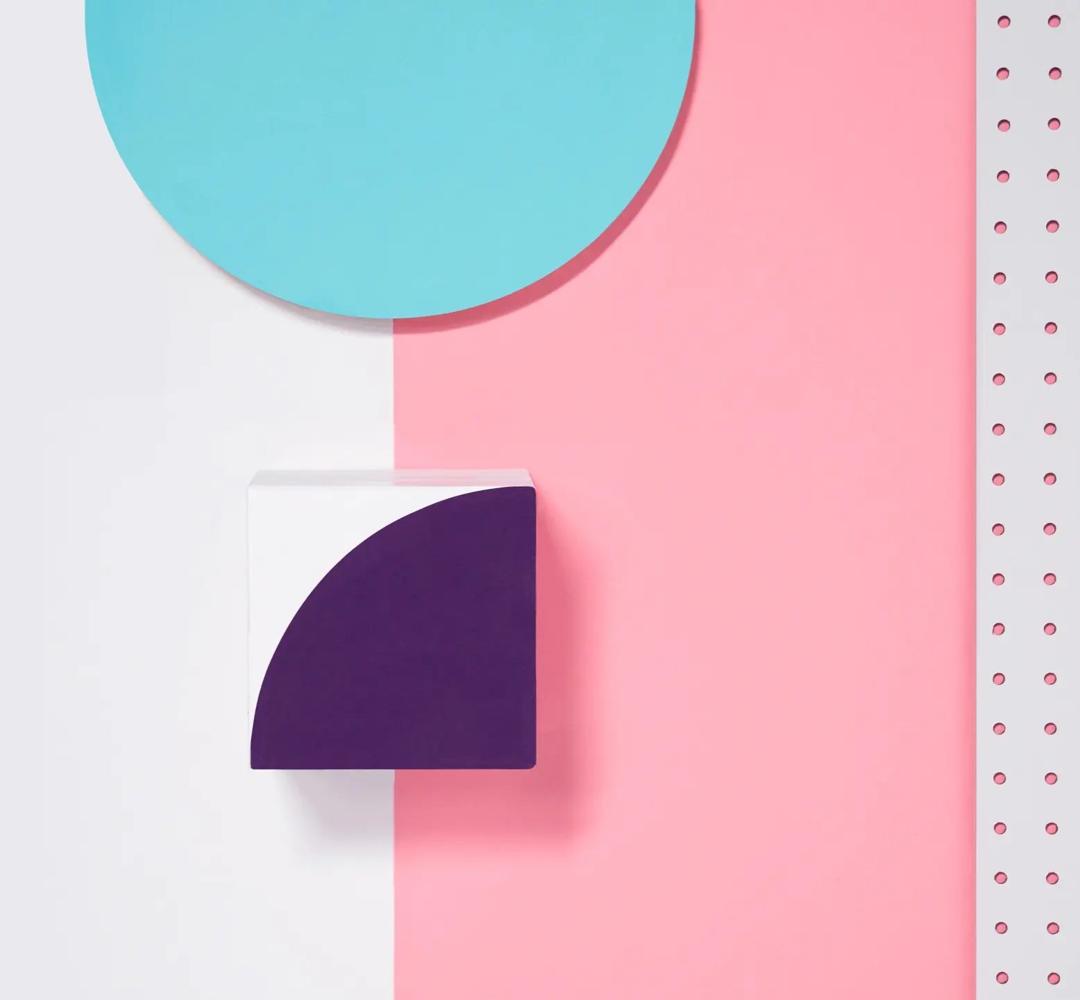 Blue circle, white and purple quarter-circle cube on split pink and white background with perforated strip.