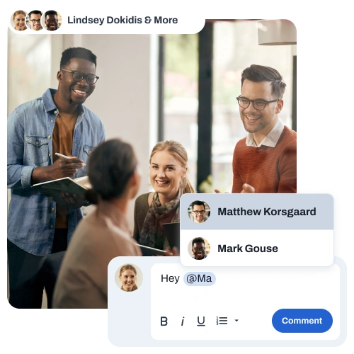 Four colleagues smiling and interacting in an office setting with a chat overlay showing user mentions for Matthew Korsgaard and Mark Gouse and a comment input box.