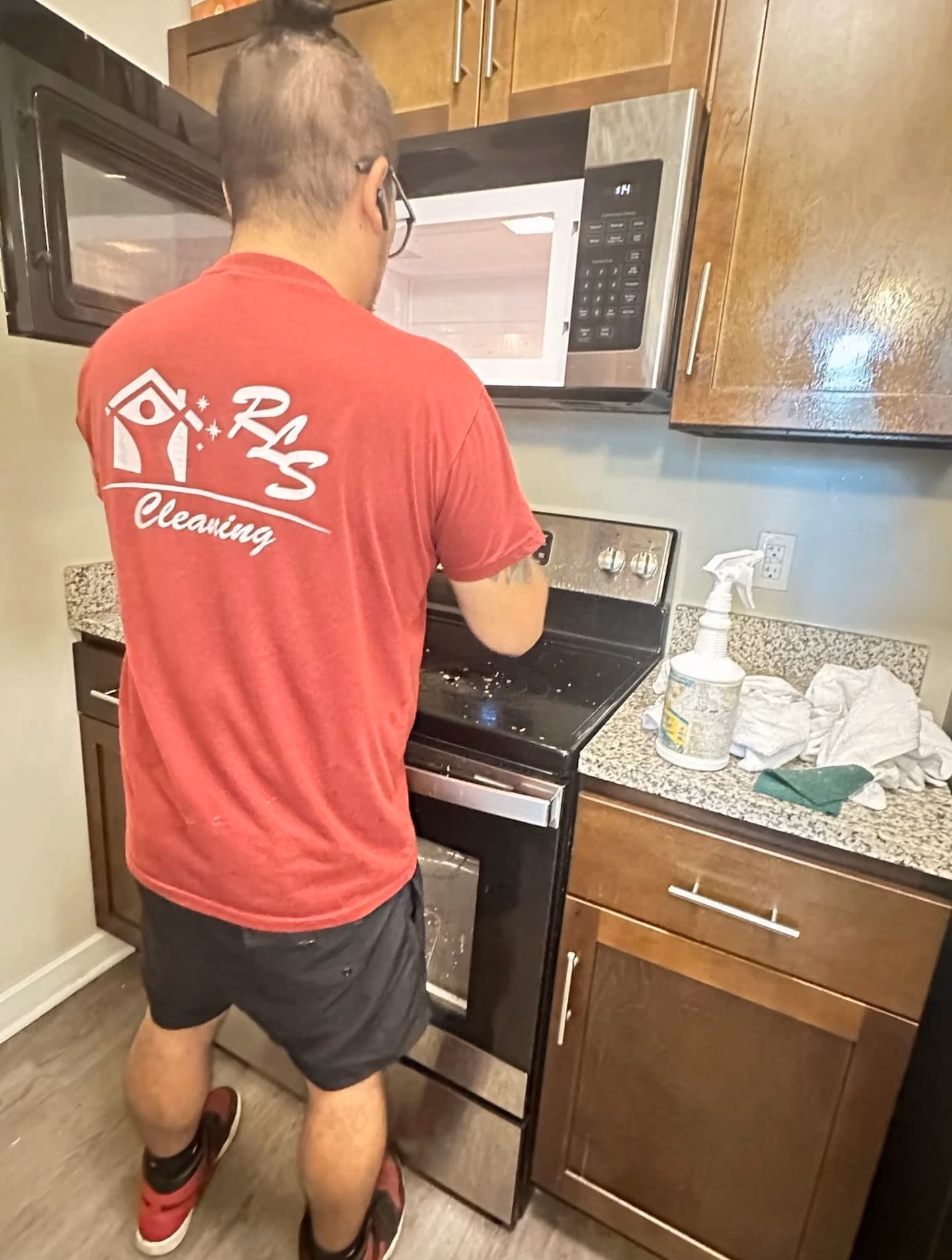 RLS Cleaning Services team member cleaning a stove and oven during an apartment turnover in Baltimore, MD