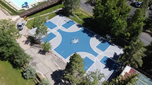 Aerial view of a blue and gray basketball play area with multiple hoops.