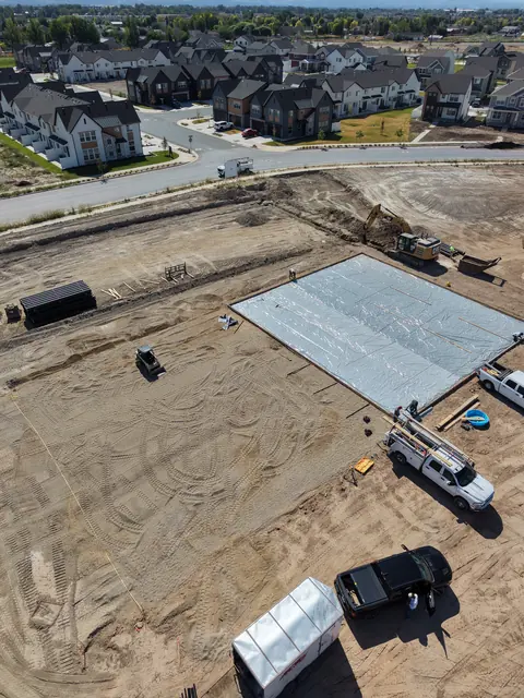 Aerial view of a prepared court slab area at a construction site.