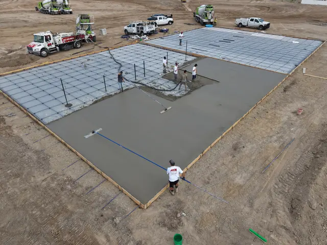Crew placing concrete over a reinforcement grid for a new court slab.