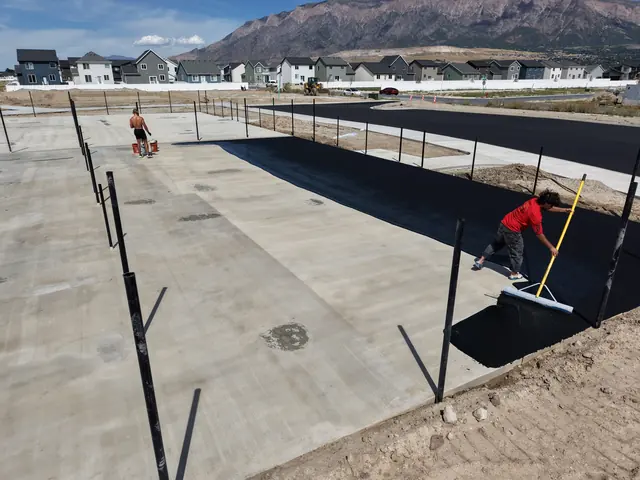 Court surface preparation inside perimeter fencing.