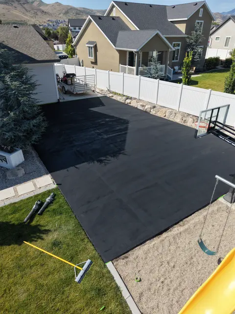 Backyard court after application of a dark base coating.
