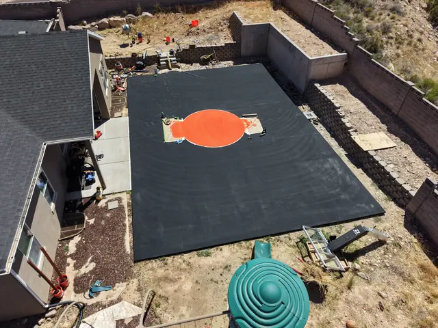 Basketball court base coating with an orange center circle before final line work.