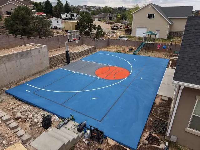 Blue backyard basketball court with an orange center circle, gray key and white lines.