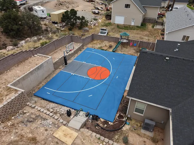Blue backyard basketball court with an orange center circle, gray key and white lines.