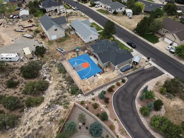 Blue backyard basketball court with an orange center circle, gray key and white lines.