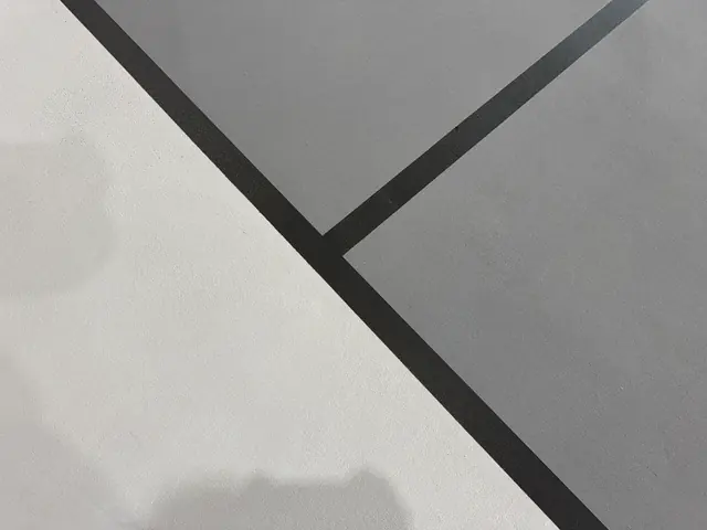 Close-up of crisp black game lines on a light gray indoor court surface.