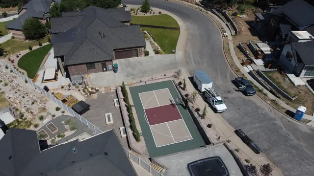 Backyard basketball court with tan playing areas, a burgundy center and dark green border.