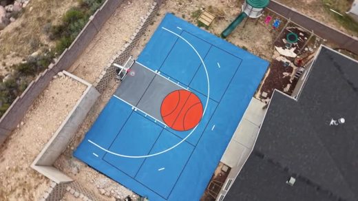 A blue basketball court with an orange circle in the key.