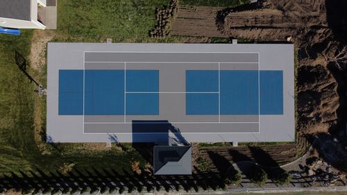 Blue and gray multi-sport court with basketball and pickleball lines.
