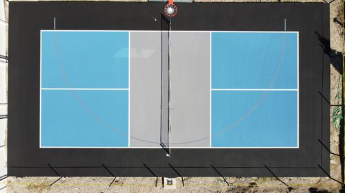 Blue court with basketball and pickleball lines and a dark perimeter.