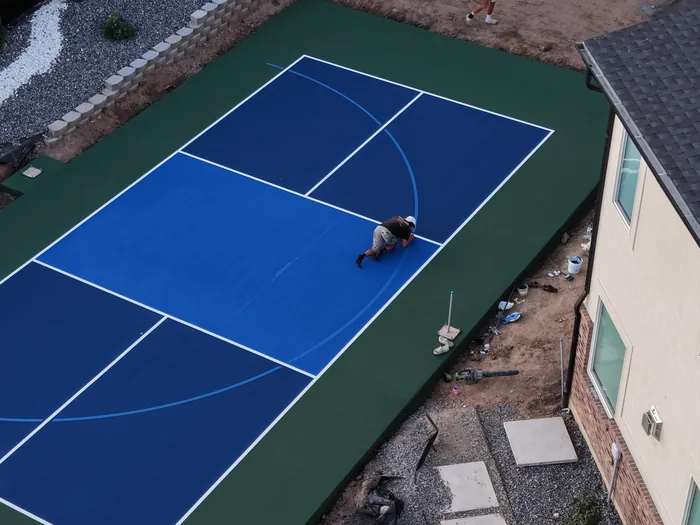 Close aerial view of blue court surfacing and white game lines in Pleasant View, Utah