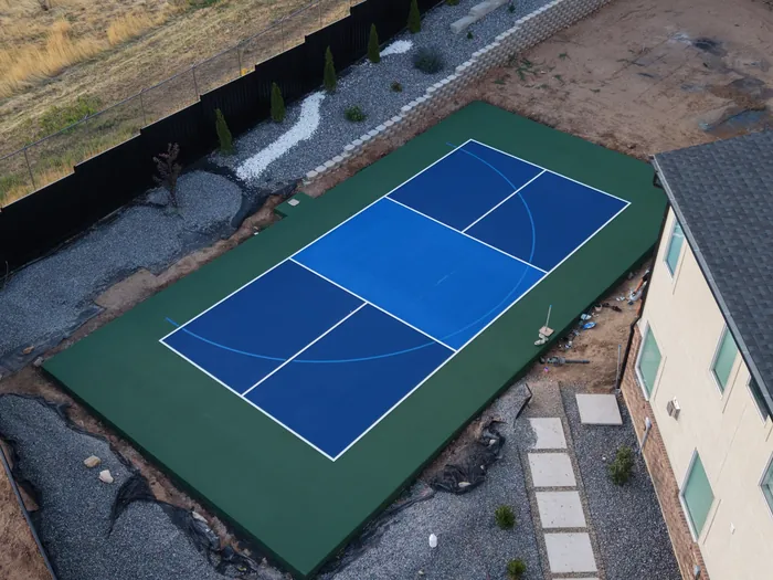 Blue backyard sport court with a green perimeter in Pleasant View, Utah