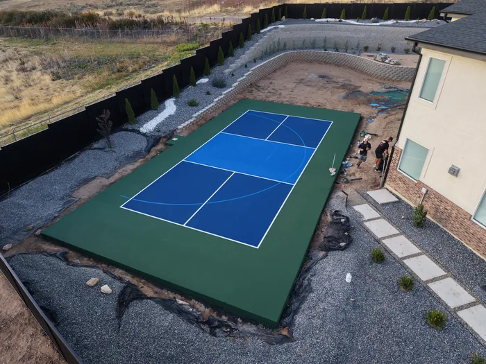 Angled aerial view of the Pleasant View backyard court and landscaped retaining wall