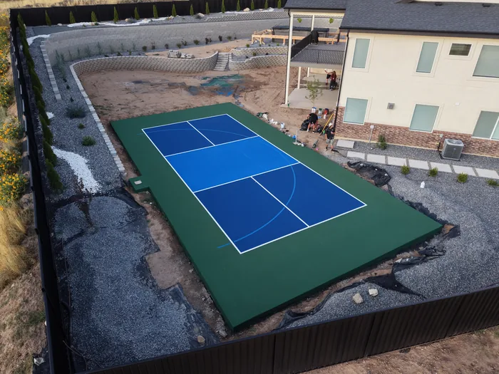 Aerial view of the blue and green Pleasant View court beside the home