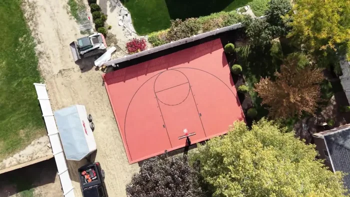 An overhead rotation shows the completed basketball court layout within the backyard.