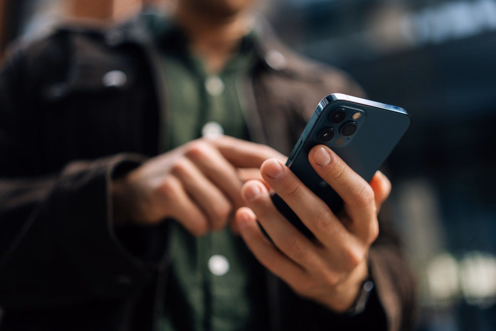 Close-up of a man holding a smartphone at night